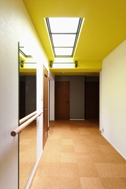 リノベのネタ帳｜廊下を有効活用　マンションリノベーション　天井がイエローのジムのような廊下スペース